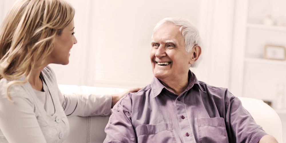 Older man sitting with younger woman indoors Older man sitting with younger woman indoors
